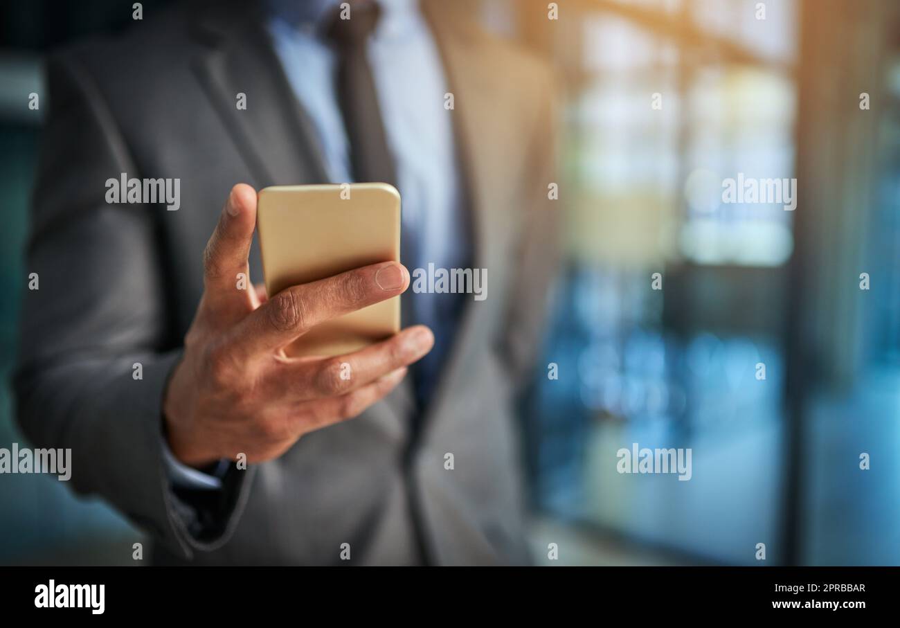 Executive hand with phone browsing, reading data or texting while working late at night or overtime on office deadline. Closeup of finance analyst monitoring, checking or following stock market trade Stock Photo