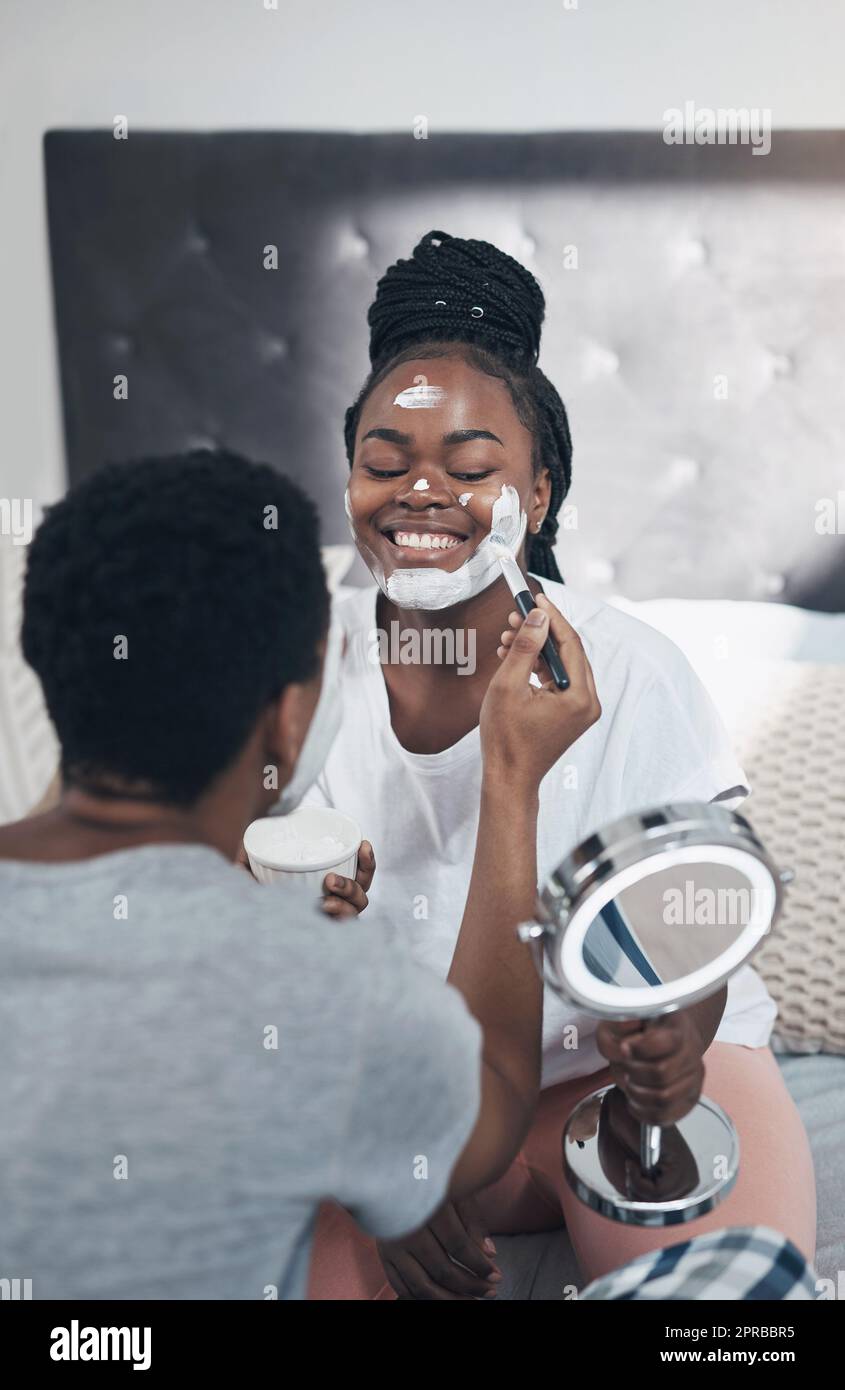 Date night doesnt always have to be movies and popcorn. a young couple getting homemade facials together at home. Stock Photo