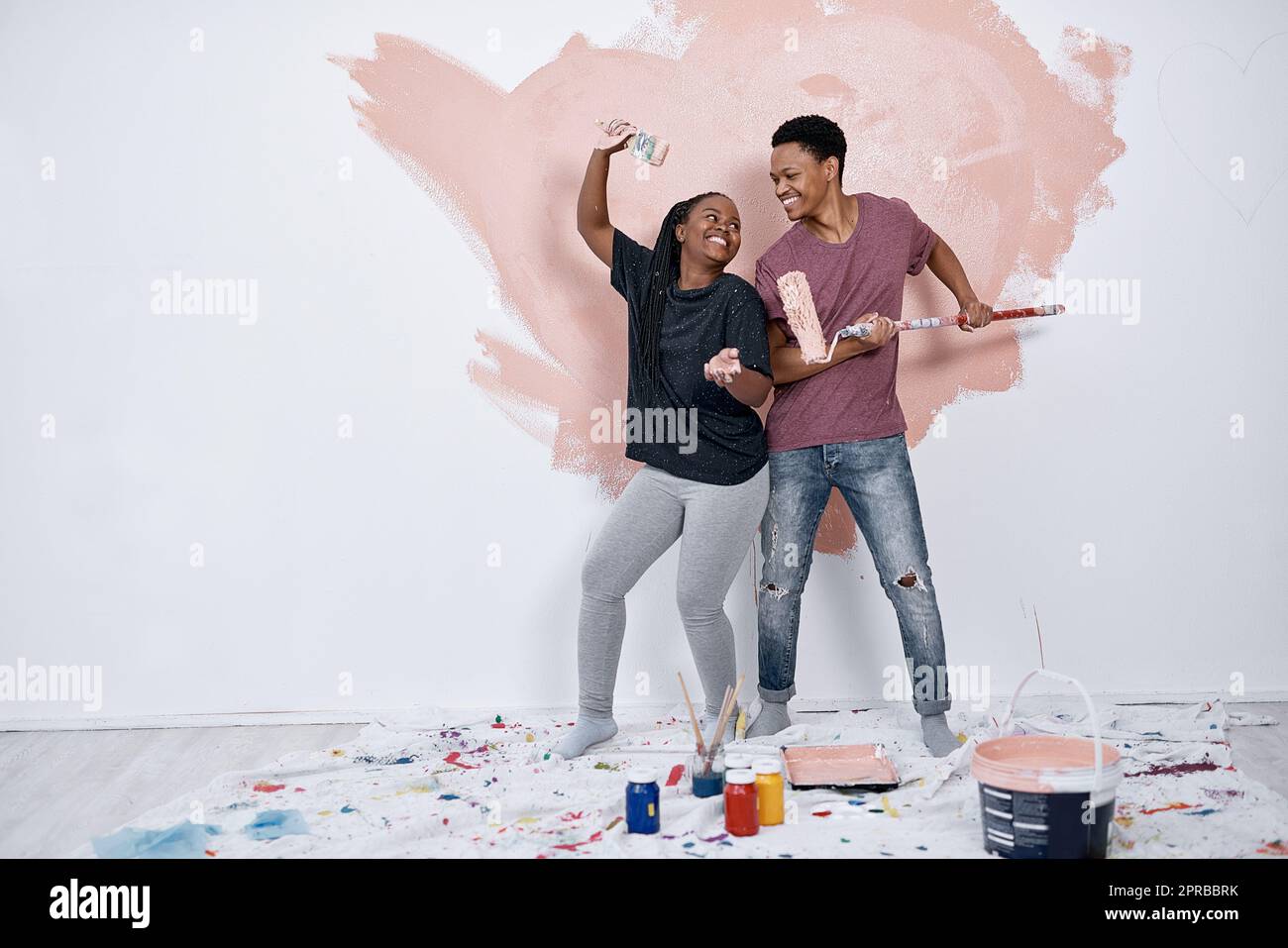 Turning a paint job into a party for two. a young couple painting a