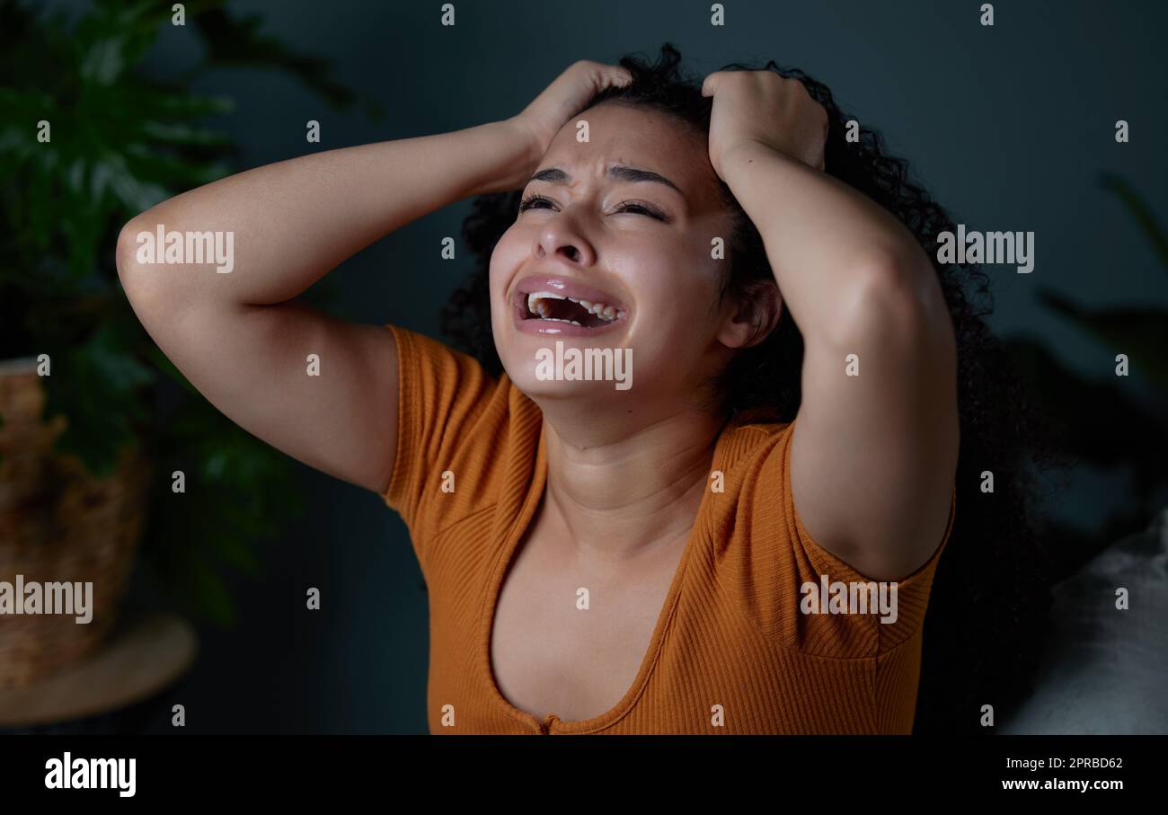 I cant believe its over. a young woman feeling unhappy at home. Stock Photo