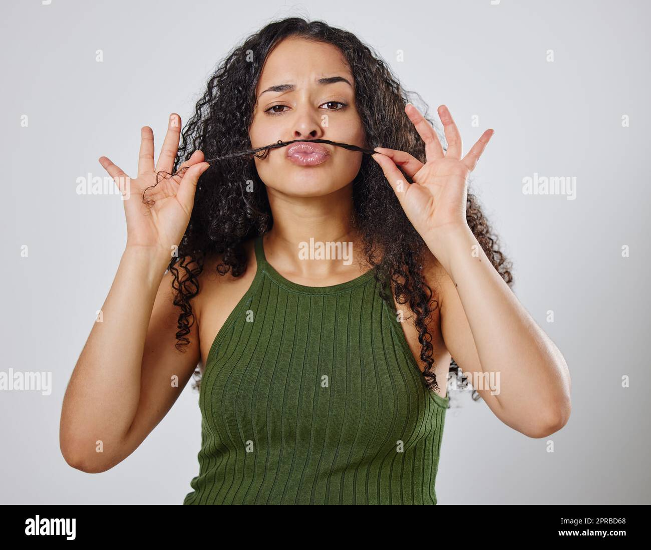 Im feeling kinda silly. a woman making a moustache with her hair. Stock Photo