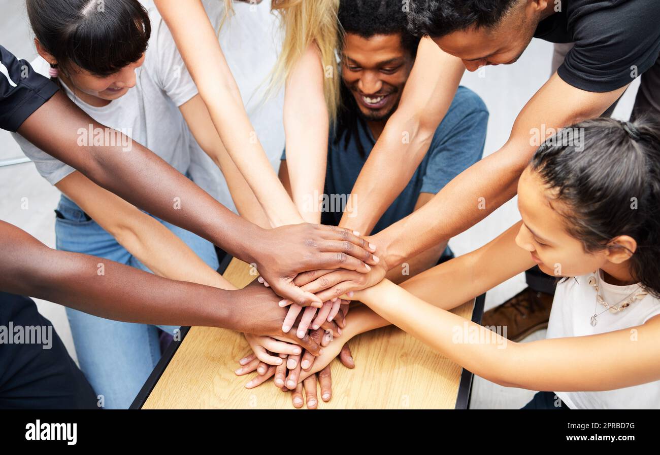 Our team will be number one. a group of coworkers huddling their hands together in a team sprit huddle. Stock Photo