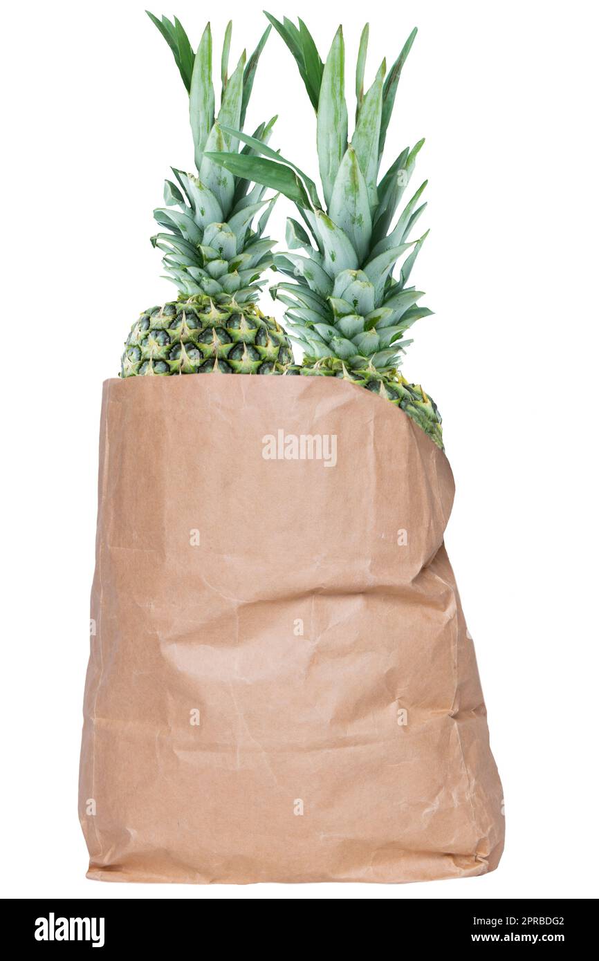 Closeup of a brown paper shopping bag with fresh ripe pineapple fruits