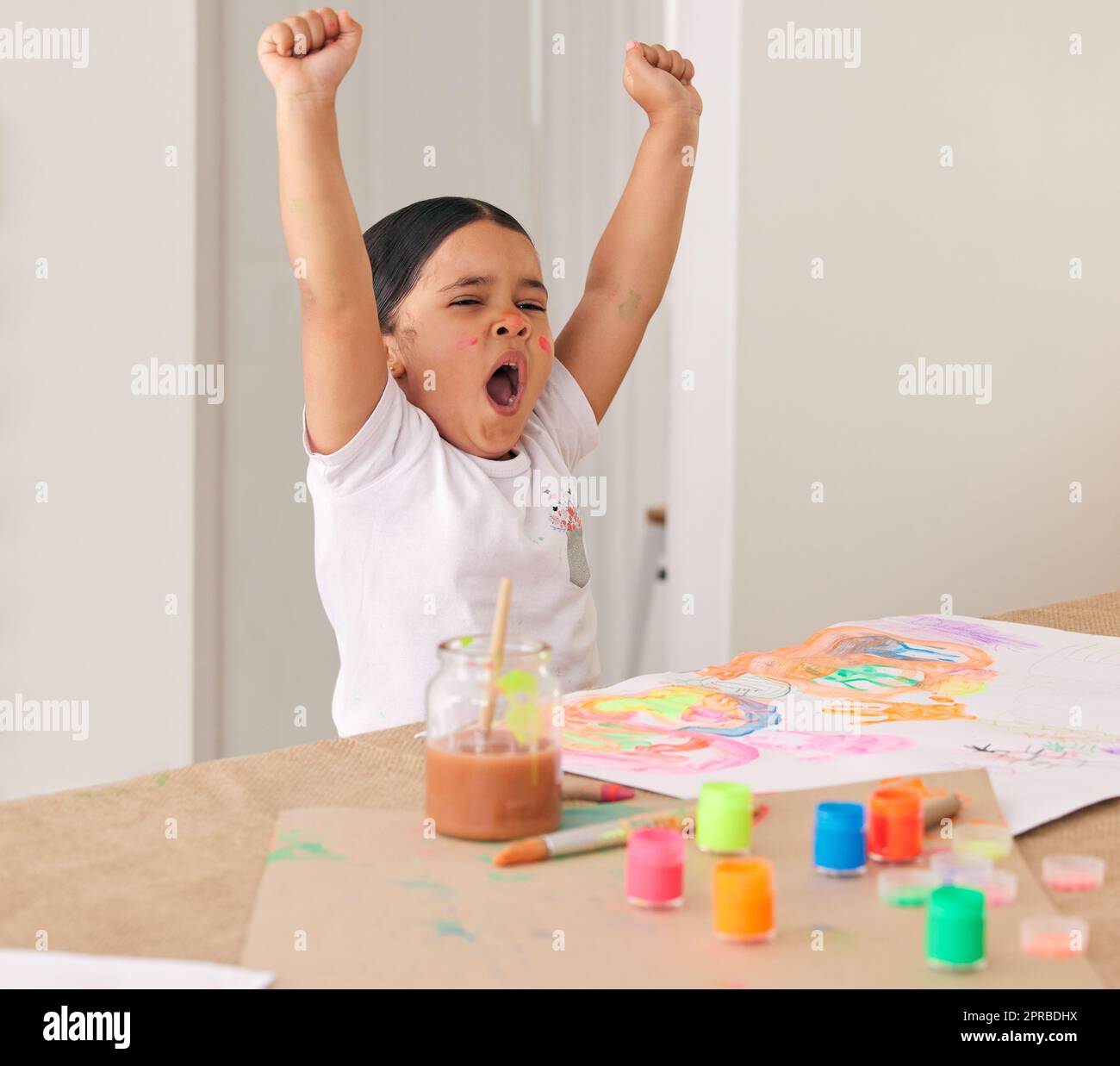 Creating art is exhausting. an adorable little girl yawning while doing