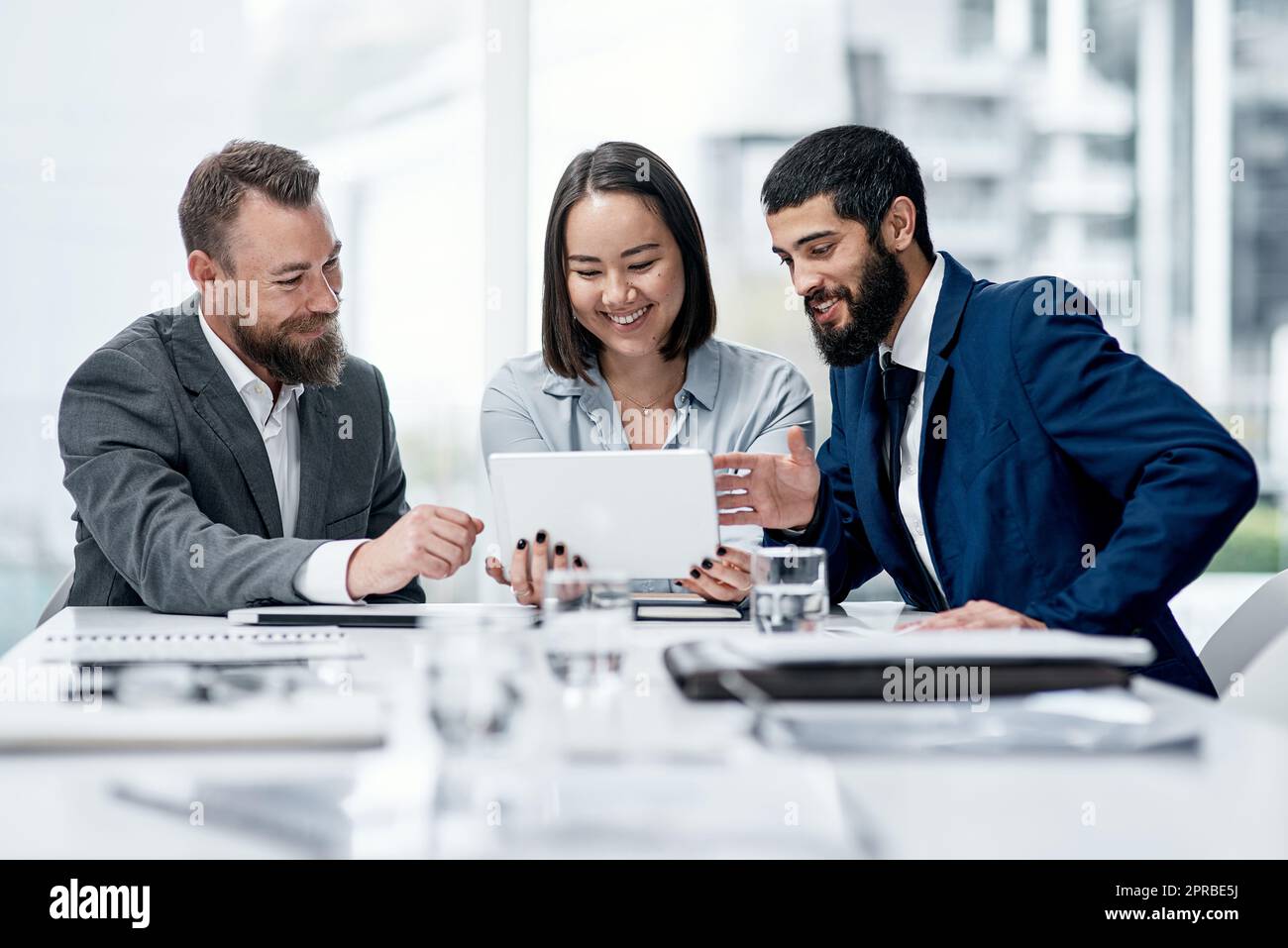 Digging deeper into a wider net of possibilities. a group of businesspeople working together on a digital tablet in an office. Stock Photo