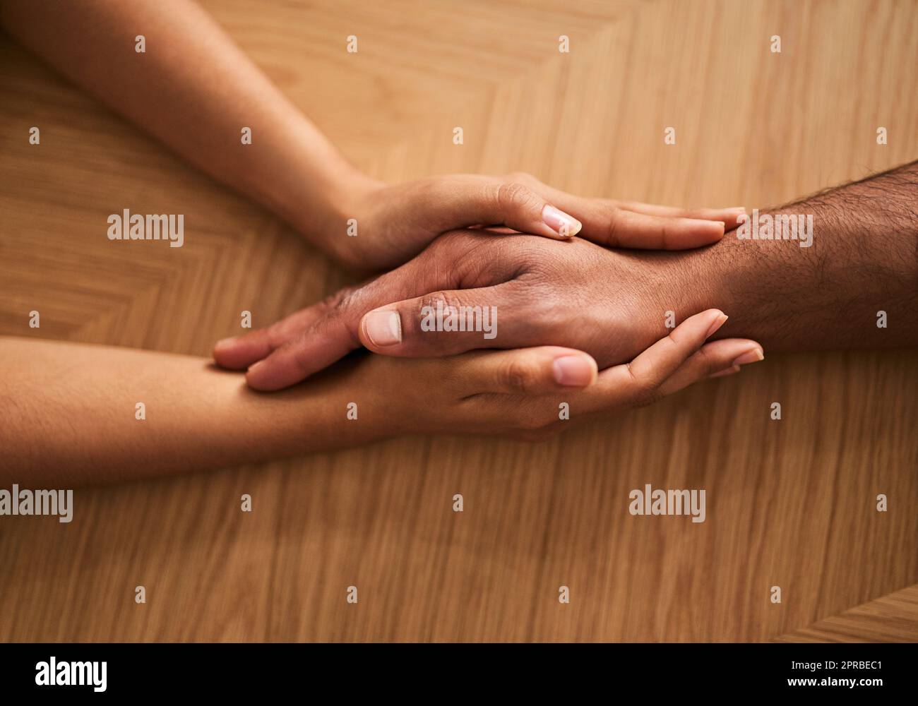 Holding hands in love and support, showing care, comfort and consoling a friend. Two people together in unity, solidarity and trust, showing hope, faith and kindness while helping and bonding closeup Stock Photo