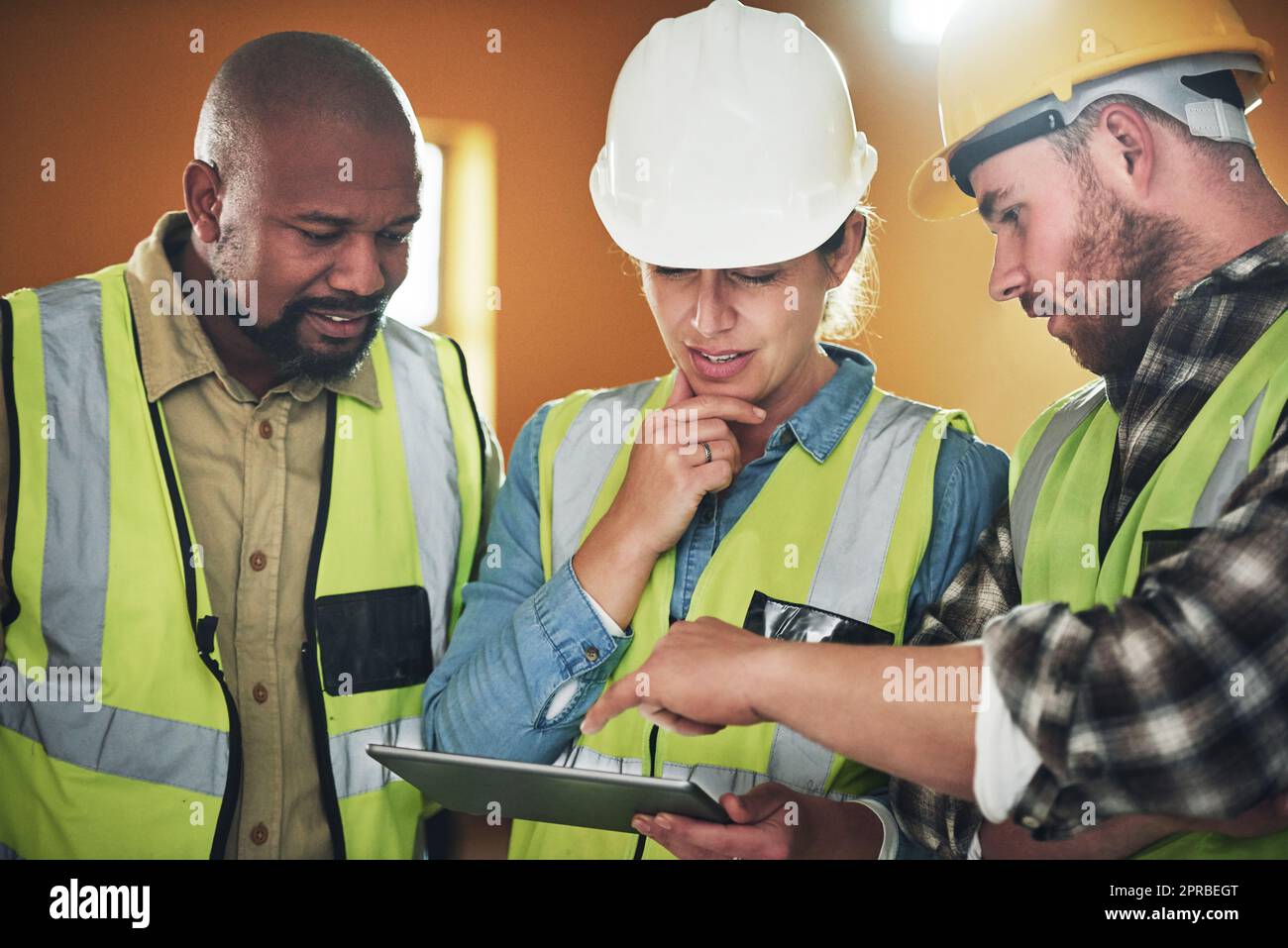 Cutting edge tech for quality construction. a group of builders using a digital tablet while working at a construction site. Stock Photo