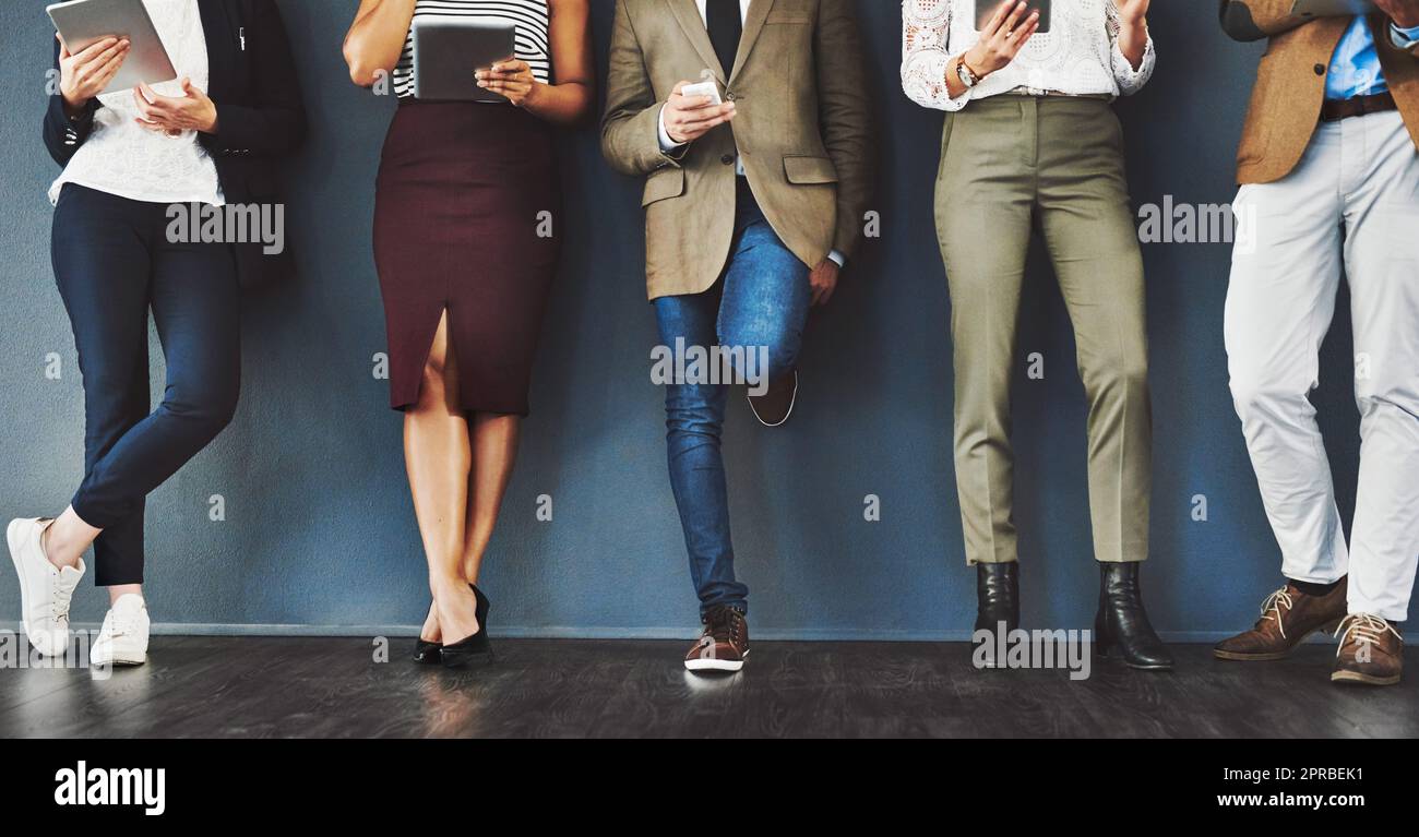 Connected, communication and network of diverse businesspeople using multimedia technology, waiting for an interview. Professional group standing in a row, browsing social media with online apps Stock Photo