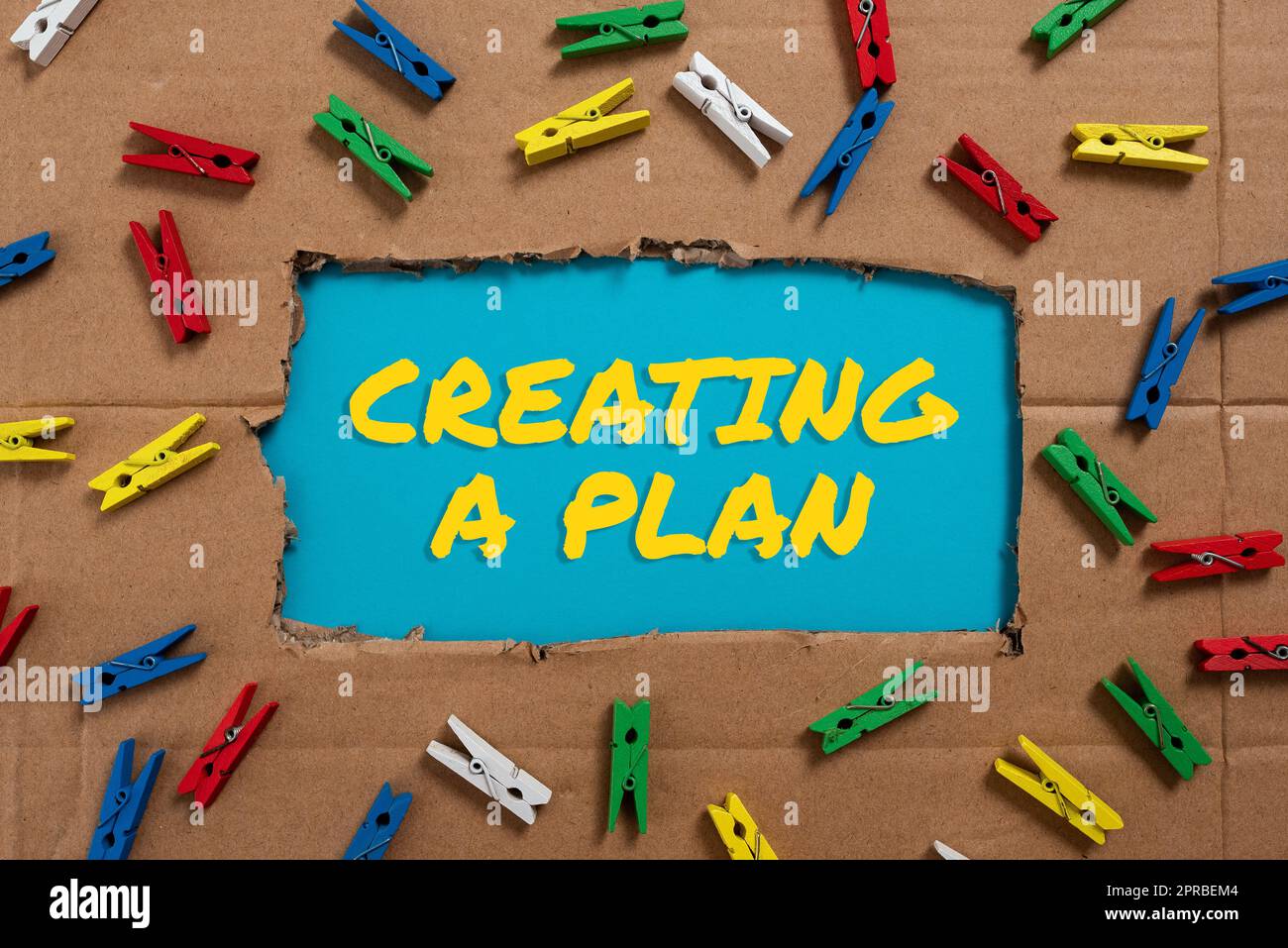 Conceptual display Creating A Plan. Business approach Establish steps to follow for a project strategy to succeed Important Ideas Written Under Ripped Cardboard With Colored Pegs Around. Stock Photo
