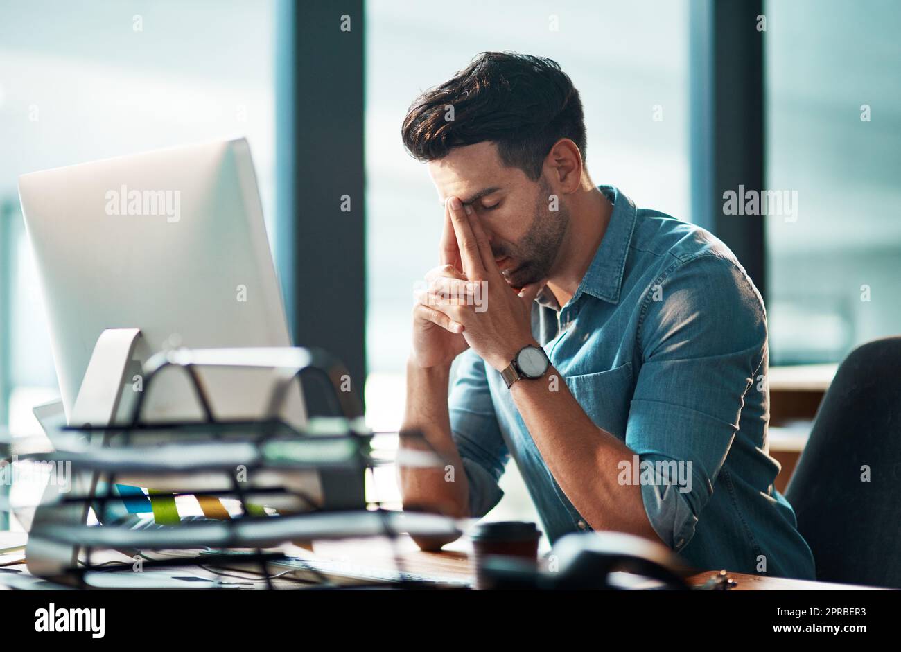 Stressed businessman with pain, headache or stress while working at office and looking tired exhausted and unhappy. Corporate worker feeling burnout and overworked failing to reach a deadline crisis Stock Photo