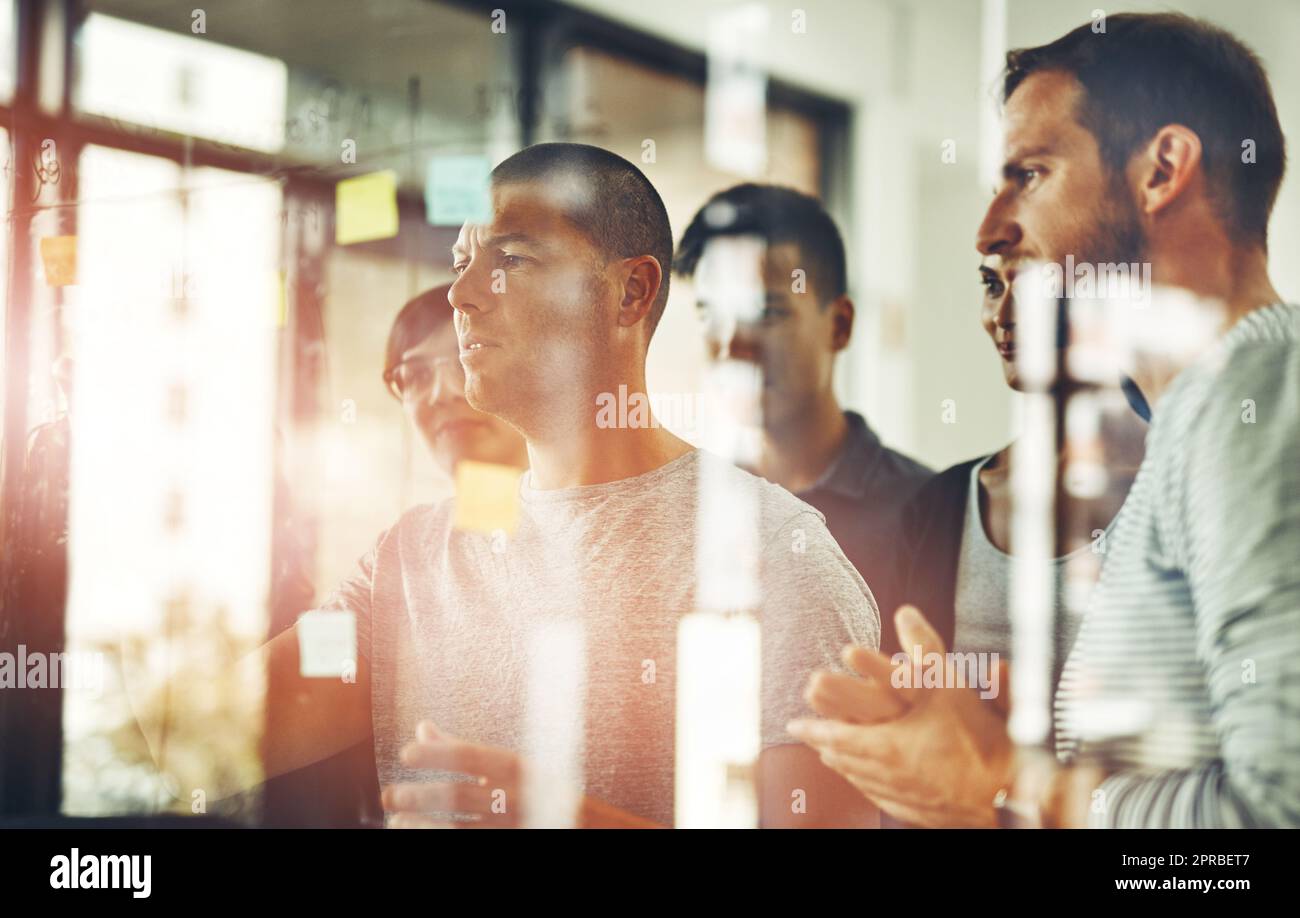 Team of colleagues planning and brainstorming in an office using sticky