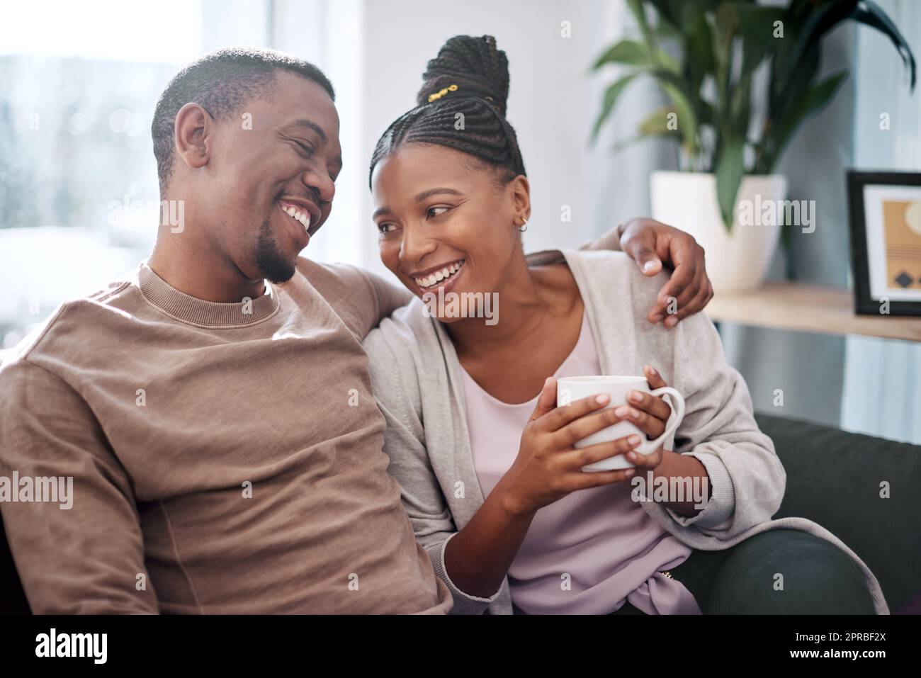 Being with you is true joy. a young couple relaxing on a sofa at home. Stock Photo