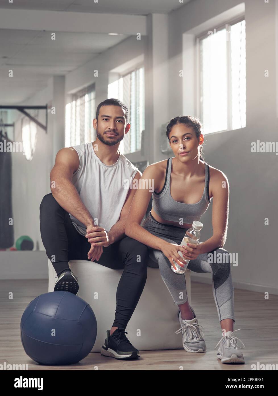 Were got 99 problems and laziness aint one. two young athletes sitting together at the gym. Stock Photo