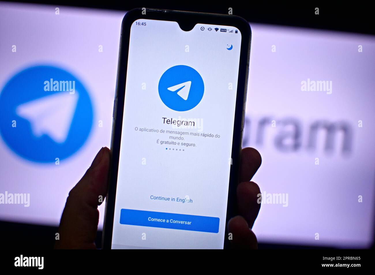 Hand holding a smartphone with telegram social network service on the screen. Stock Photo
