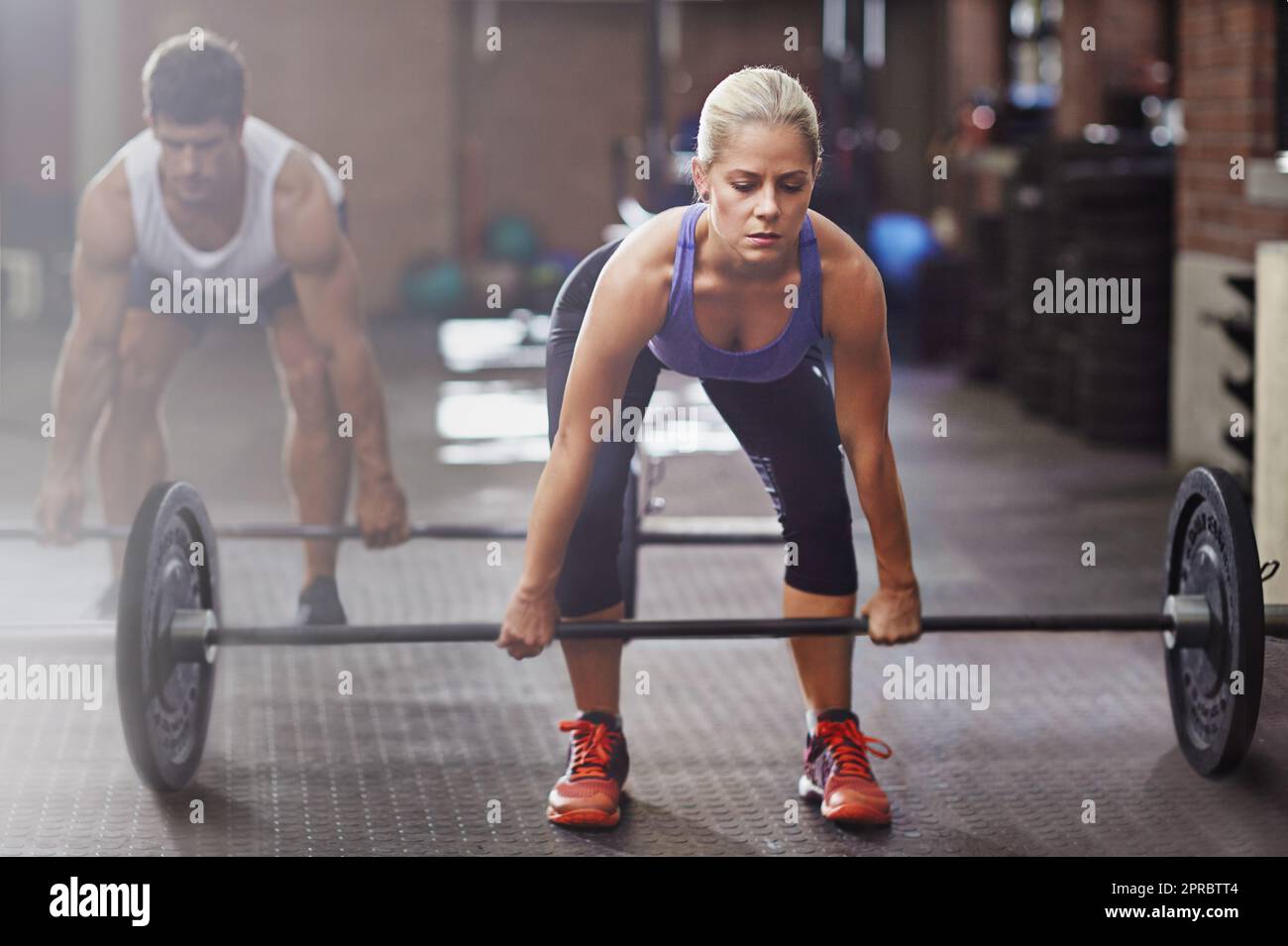 Showing the boys how its done. two people lifting weights in a gym