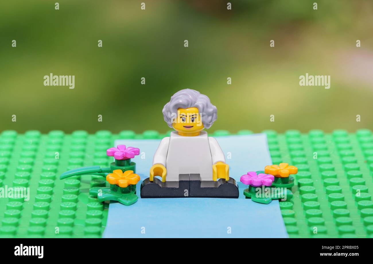 Active senior woman practicing yoga outdoors in nature. Ageing better healthy habits concept illustrated with Lego minifigure parts (MOC) Stock Photo