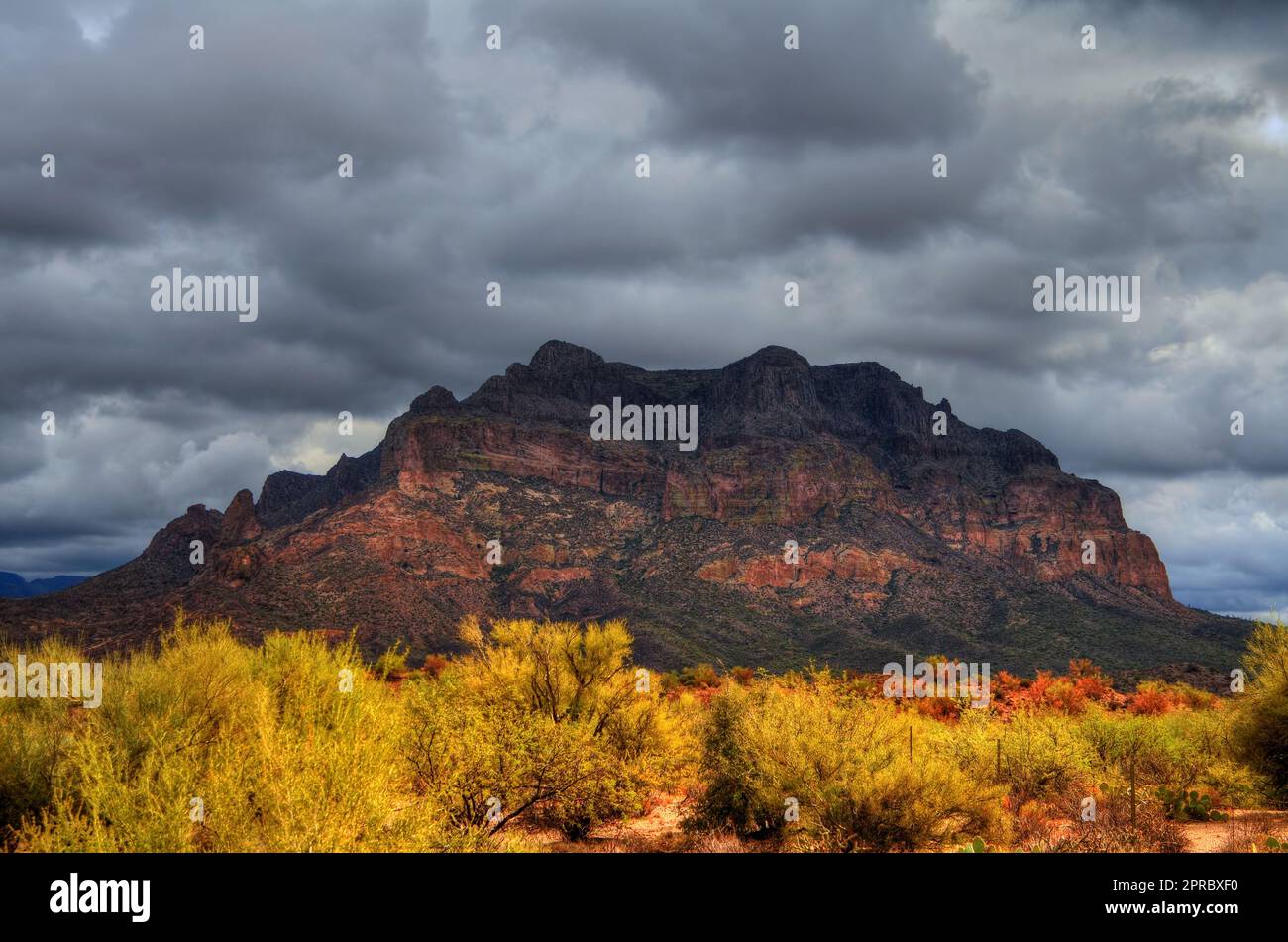 Storm forming over a rugged desert mountain Stock Photo