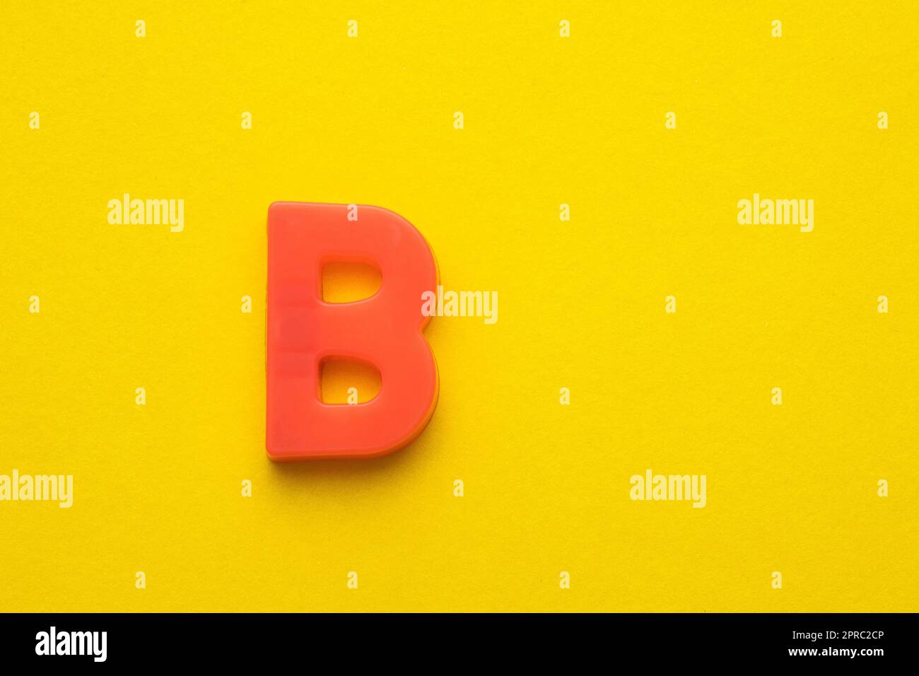 Alphabet letter B - Peach colored plastic piece on yellow foamy ...