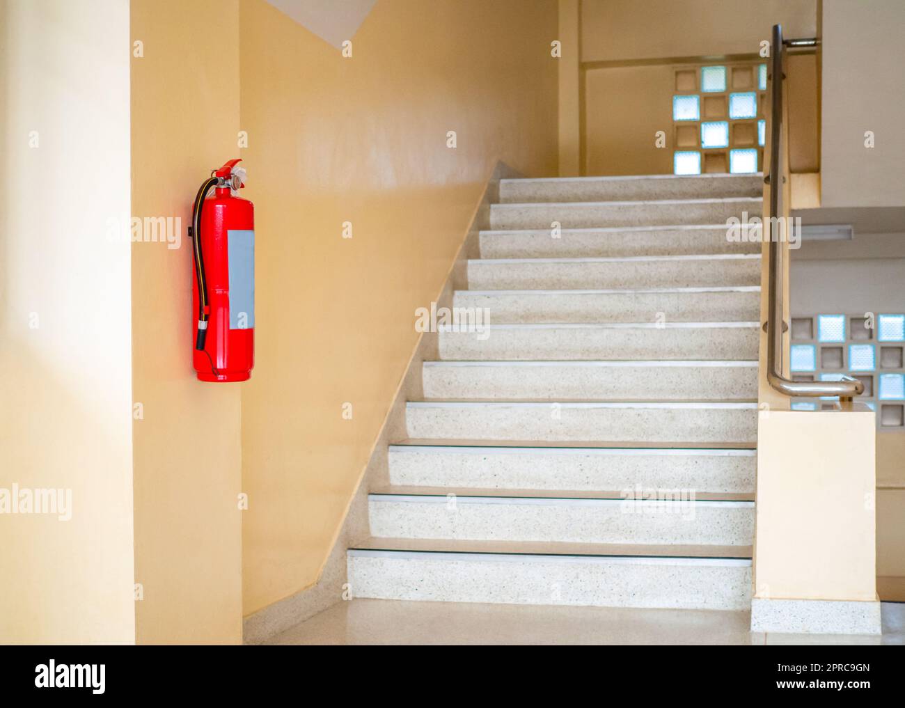 A fire extinguisher hangs up the stairs. Fire safety concept Stock
