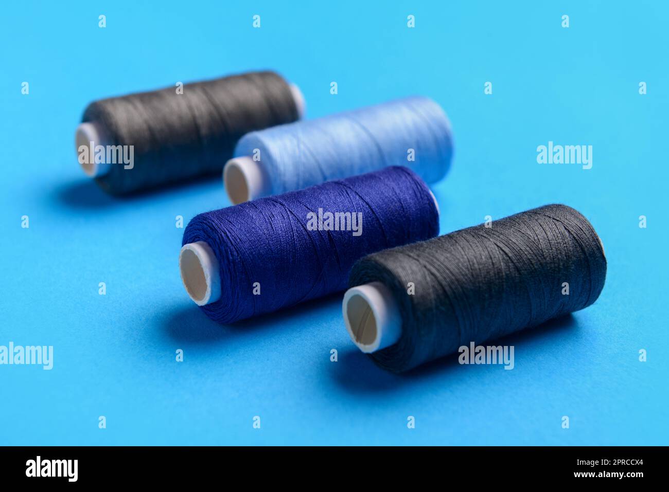 Different threads on color background Stock Photo - Alamy