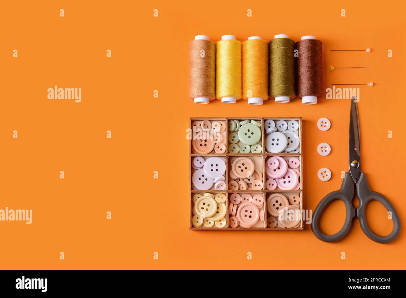 Composition with different thread spools and sewing supplies on color background Stock Photo