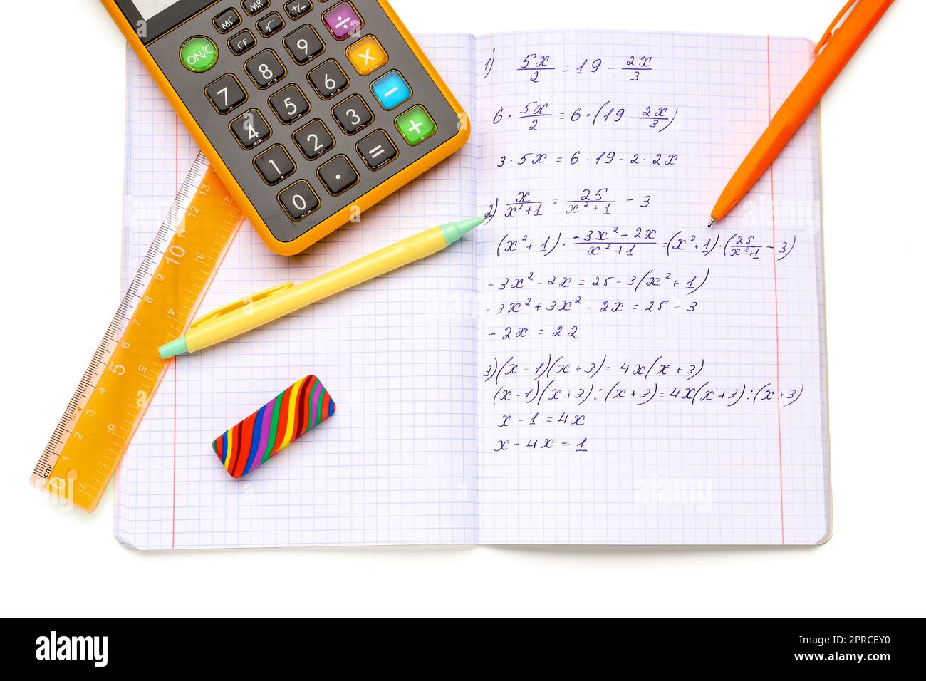 Copybook with maths formulas, calculator and stationery isolated on