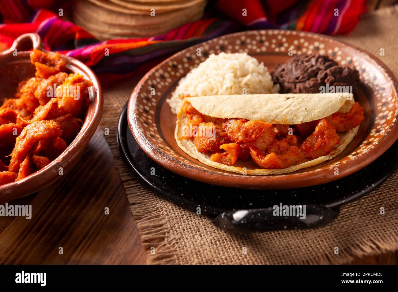 Pork rinds in red sauce Taco accompanied by rice and refried beans. Traditional homemade dish very popular in Mexico, this dish is part of the popular Stock Photo
