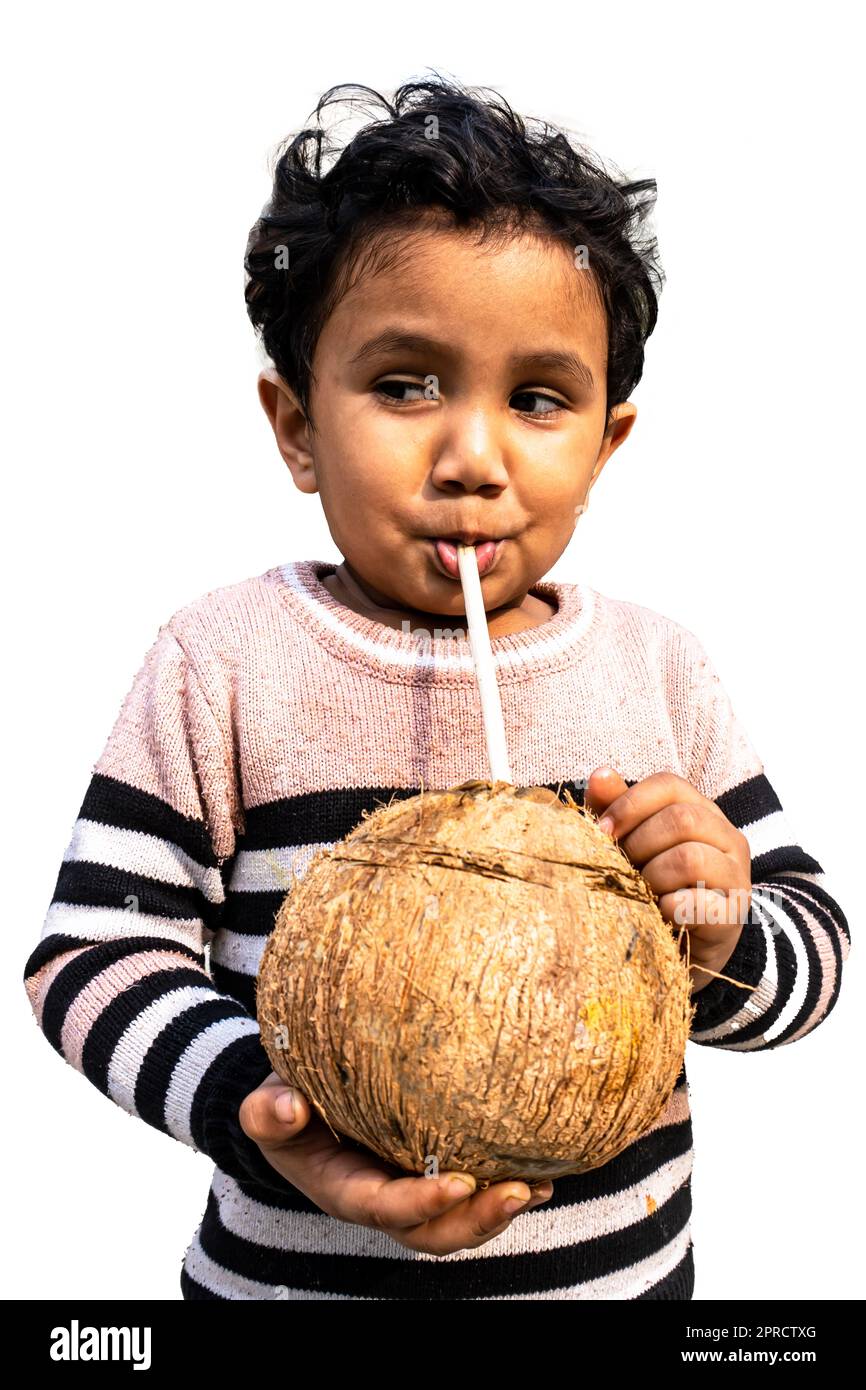 Little boy drinking coconut water in the yard with pleasure Stock Photo