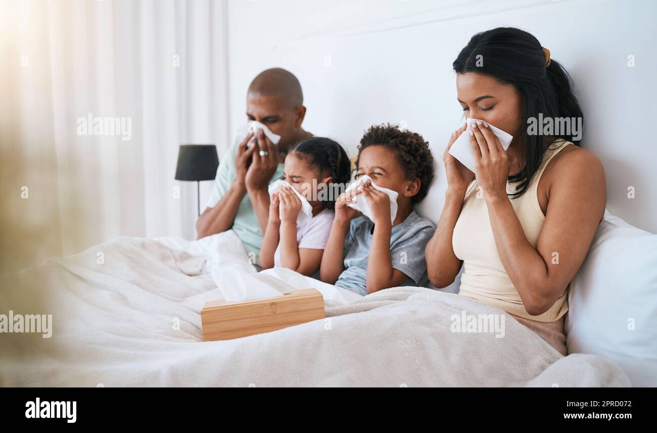 Sick, flu and family on a bed, tissue and blowing nose with illness