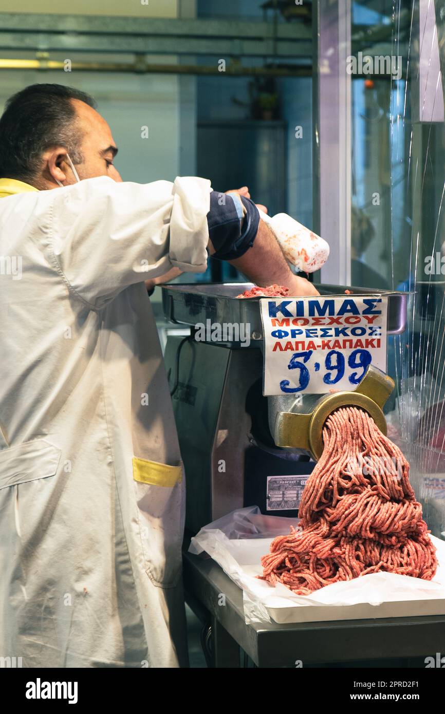 Market vendor in Athens Greece mincing beef to sell Stock Photo