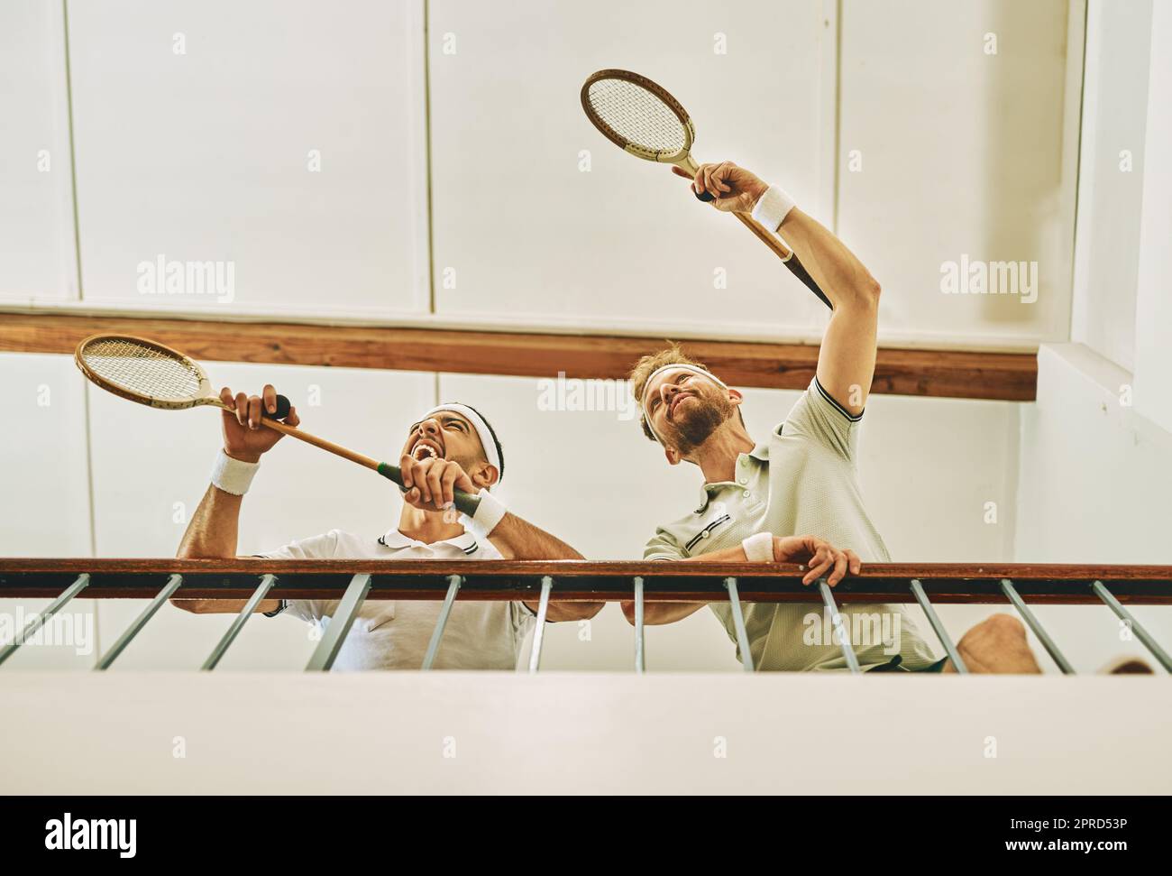 Youll find the winners at the top. two young men watching a game of squash from the viewing gallery. Stock Photo