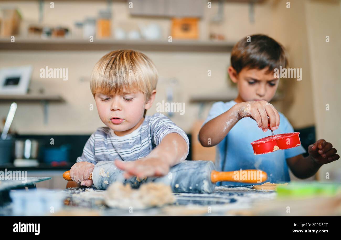 The cutest cookie makers in town. two adorable little boys baking together at home. Stock Photo