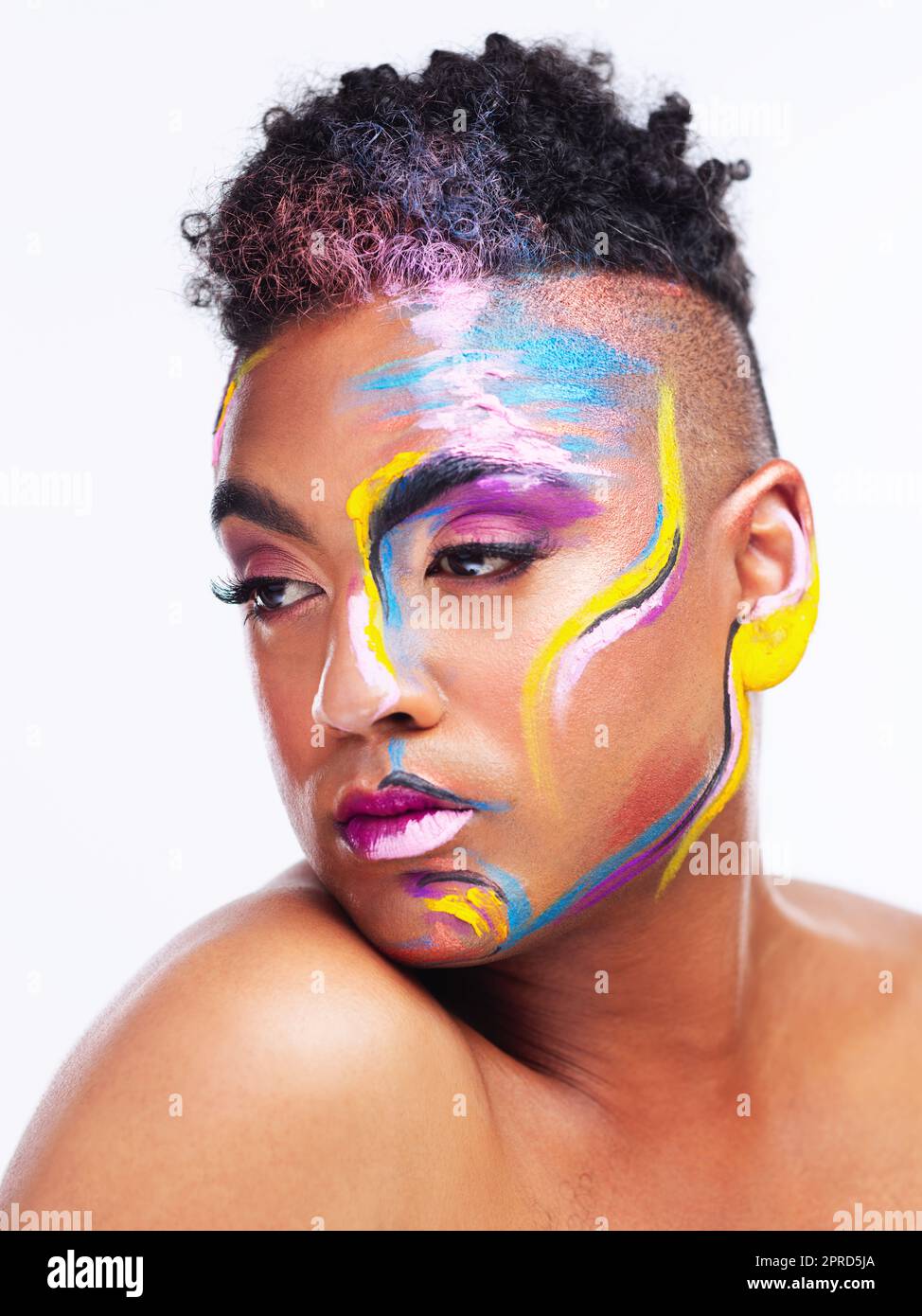 Were all living in a world of color. a gender fluid young man wearing face paint against a white