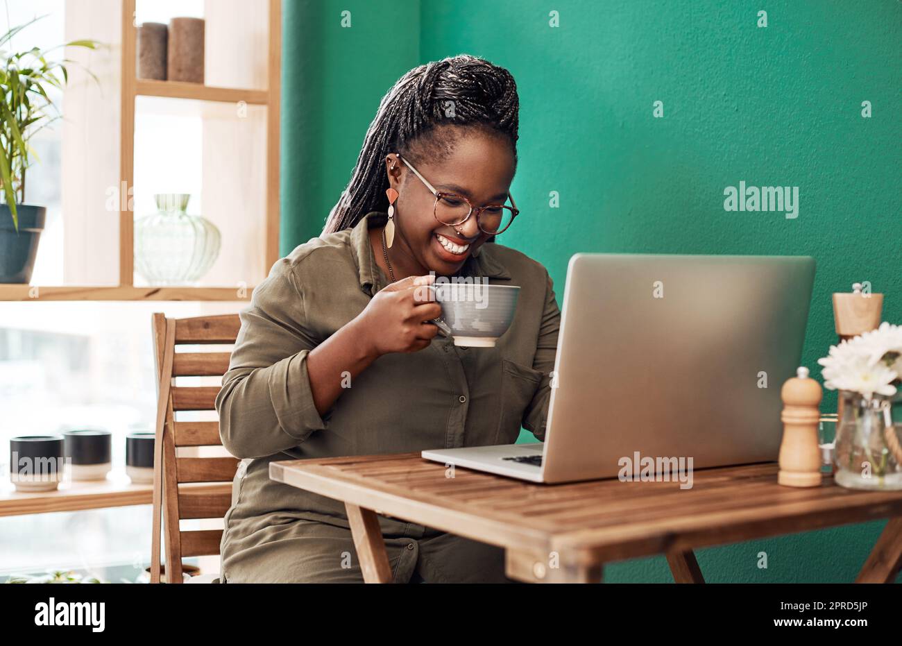 Welcome to the age of the freelancer. a young woman having coffee and using a laptop at a cafe. Stock Photo