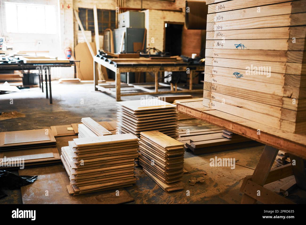 Were stocked up on the finest wood in the industry. Still life shot of piles of wood stacked inside a carpentry workshop. Stock Photo