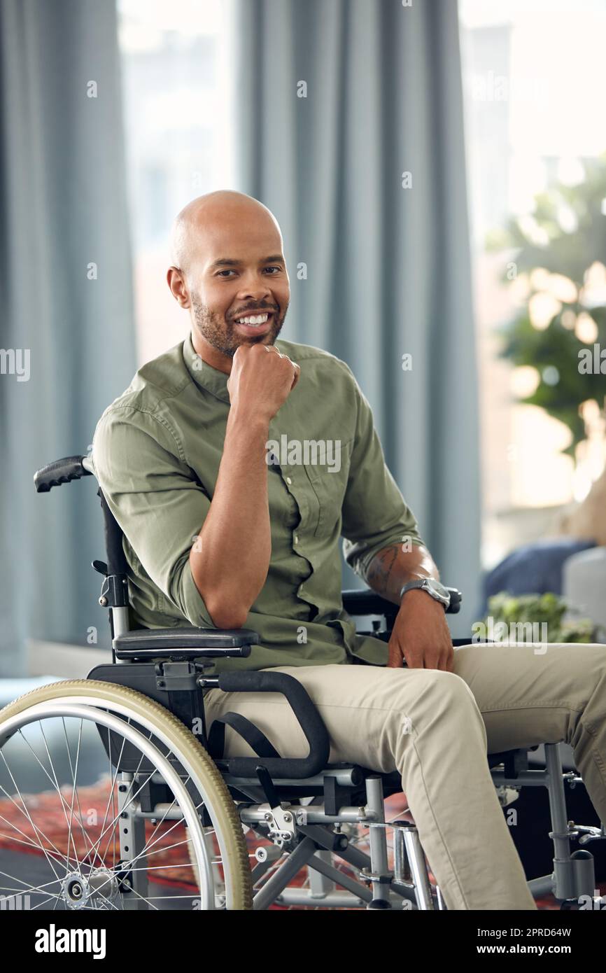I want to share my story. a young man sitting in his wheelchair at home. Stock Photo