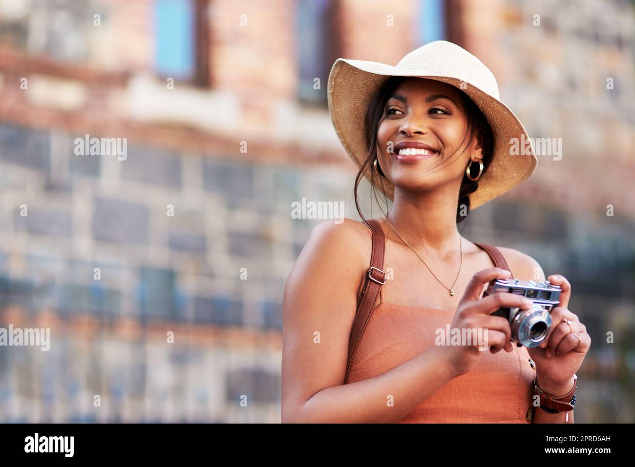 These pictures will always remind me of this wonderful city. an attractive young woman taking pictures with a camera while exploring in a foreign city. Stock Photo