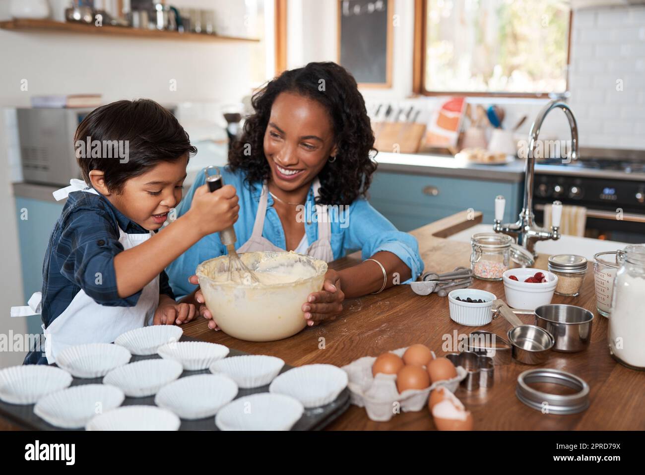 Whisk away little chef. a woman baking at home with her young son Stock