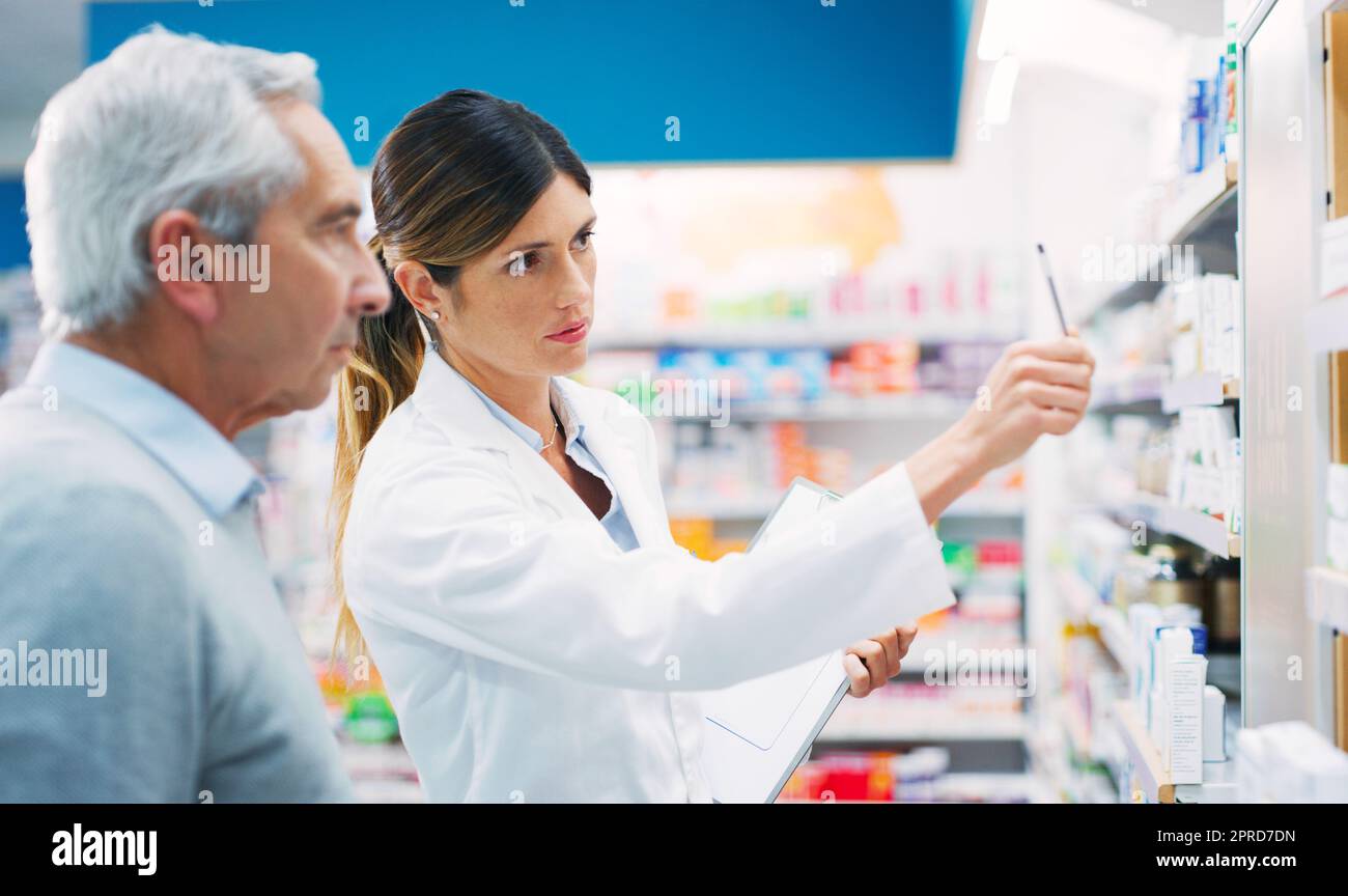 If you want my advice, take this one. a pharmacist assisting a customer in a chemist. Stock Photo