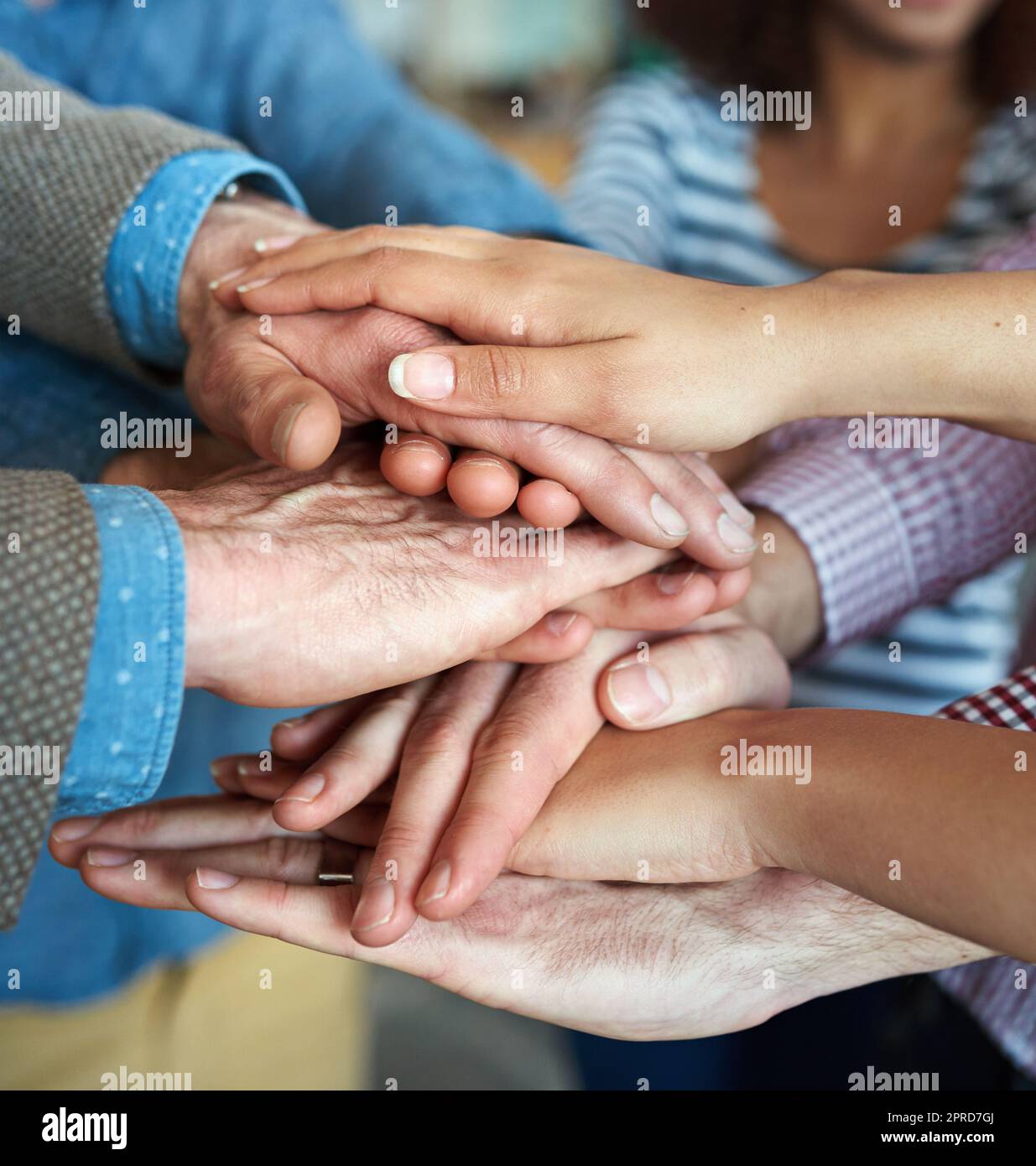 Hands stacked and piled to show team unity, strength or motivation among business men, women or office colleagues. Closeup of huddled group of casual businesspeople showing support, trust or teamwork Stock Photo