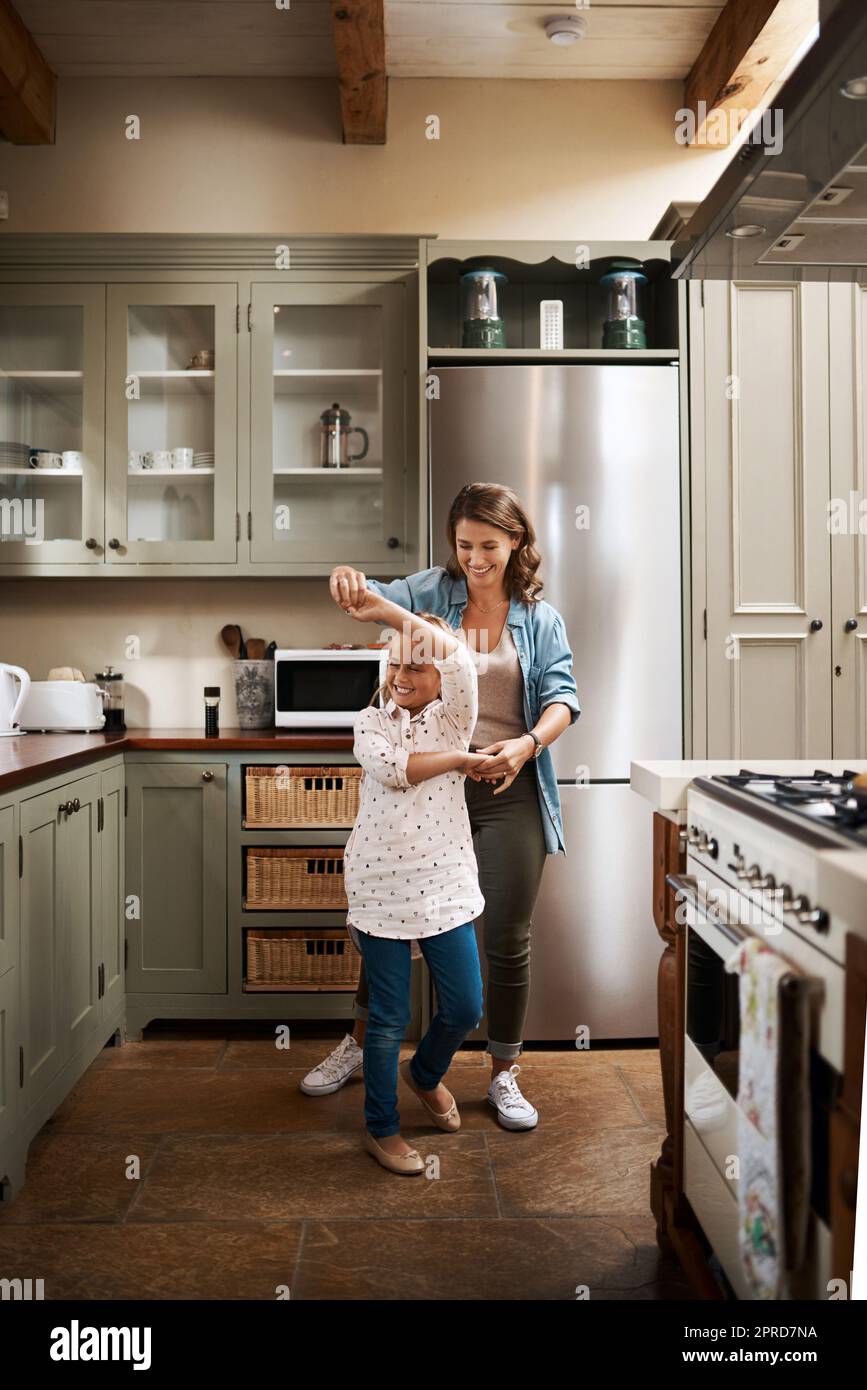 We know how to entertain ourselves. a young girl dancing at home with her mother. Stock Photo