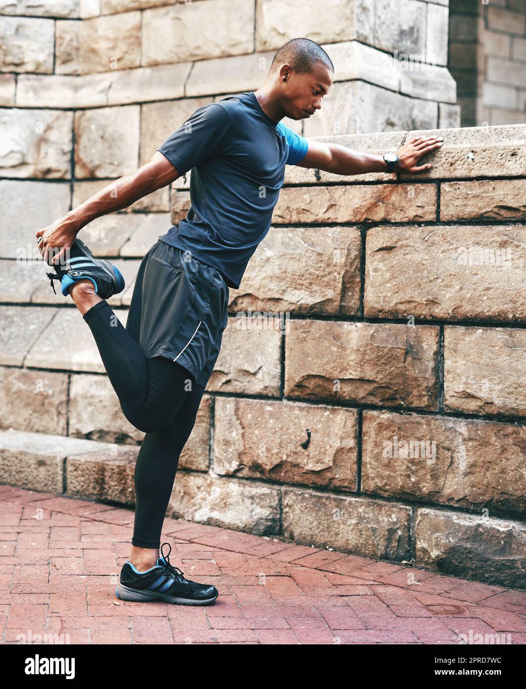 Preparation is always key. Full length shot of a handsome young sportsman stretching and warming before exercising outdoors in the city. Stock Photo