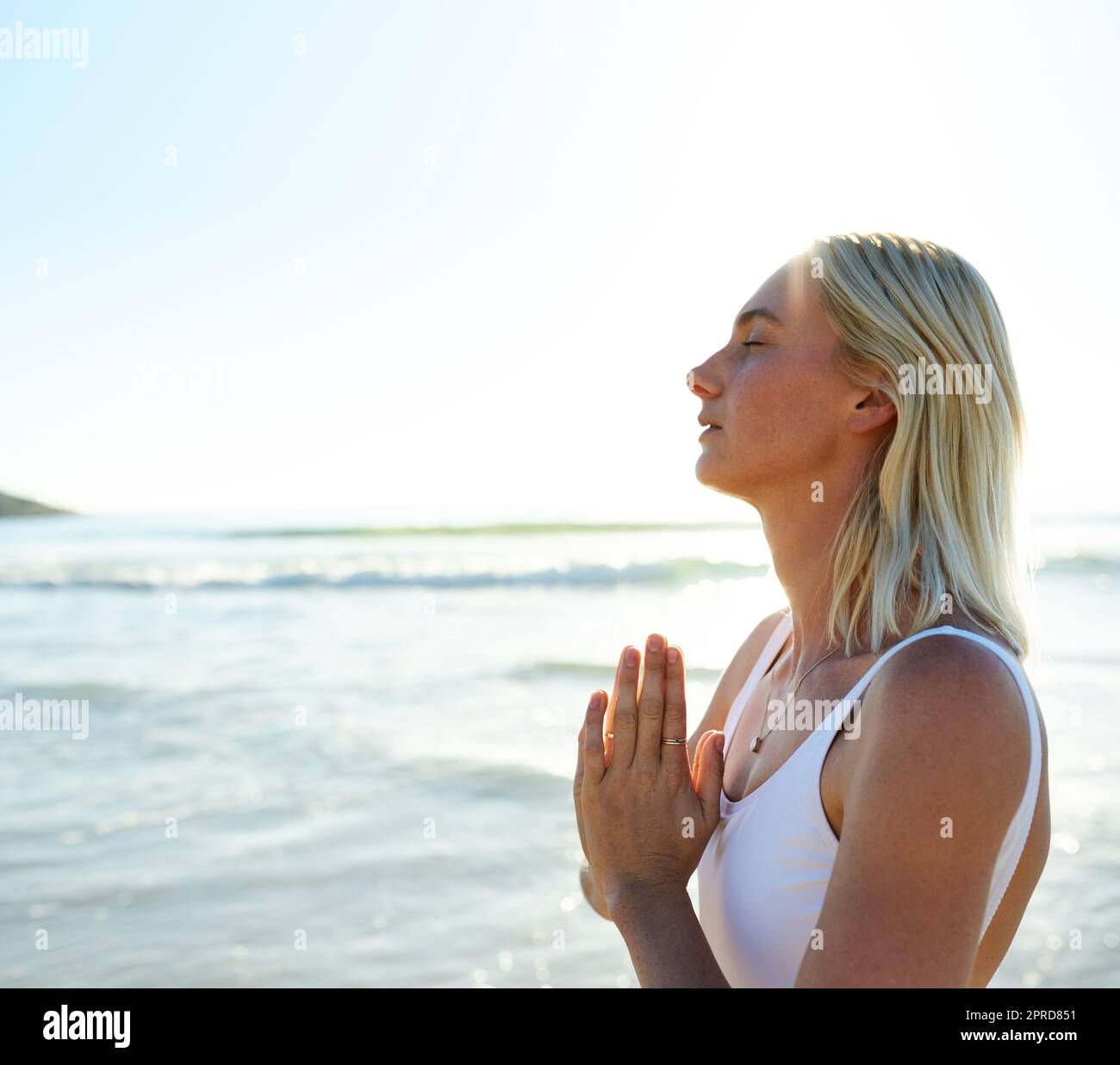 Finding the peace within my soul. an attractive young woman meditating early in the morning on the beach. Stock Photo