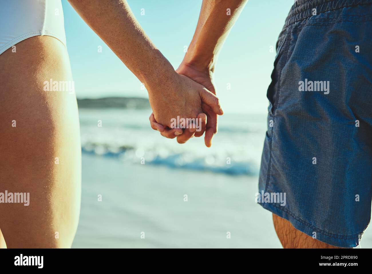 All s well when youre by my side. Closeup shot of a couple holding hands at the beach. Stock Photo