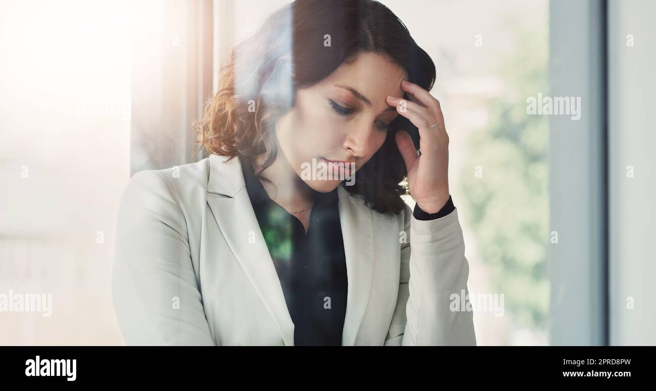 This feeling is more than she can handle. an attractive young businesswoman feeling stressed out at work. Stock Photo