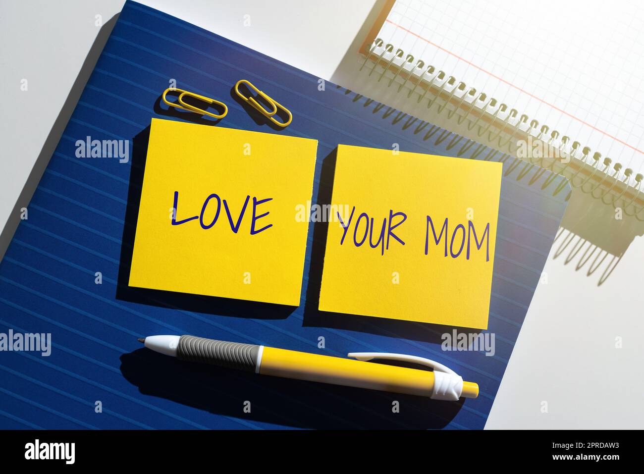 Handwriting text Love Your Mom. Concept meaning Have good feelings about your mother Loving emotions Important News Presented On Two Sticky Notes On Desk With Notebook And Pen. Stock Photo