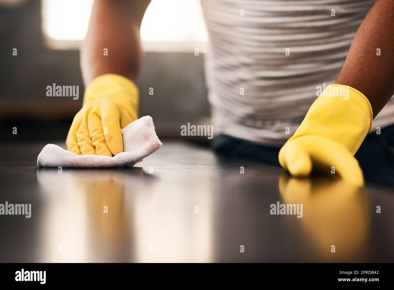 Ill keep wiping until its spotless. an unrecognizable man cleaning a kitchen counter at home. Stock Photo