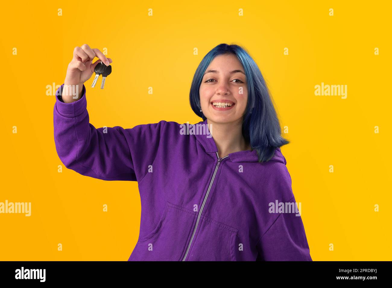 Smiling young woman student with blue hair holding keys Stock Photo - Alamy