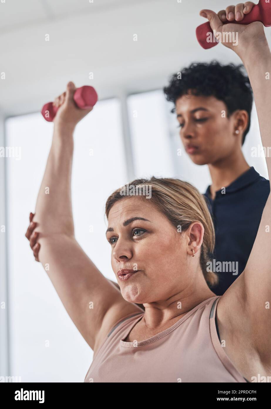 Female physiotherapist helping patient exercise hires stock