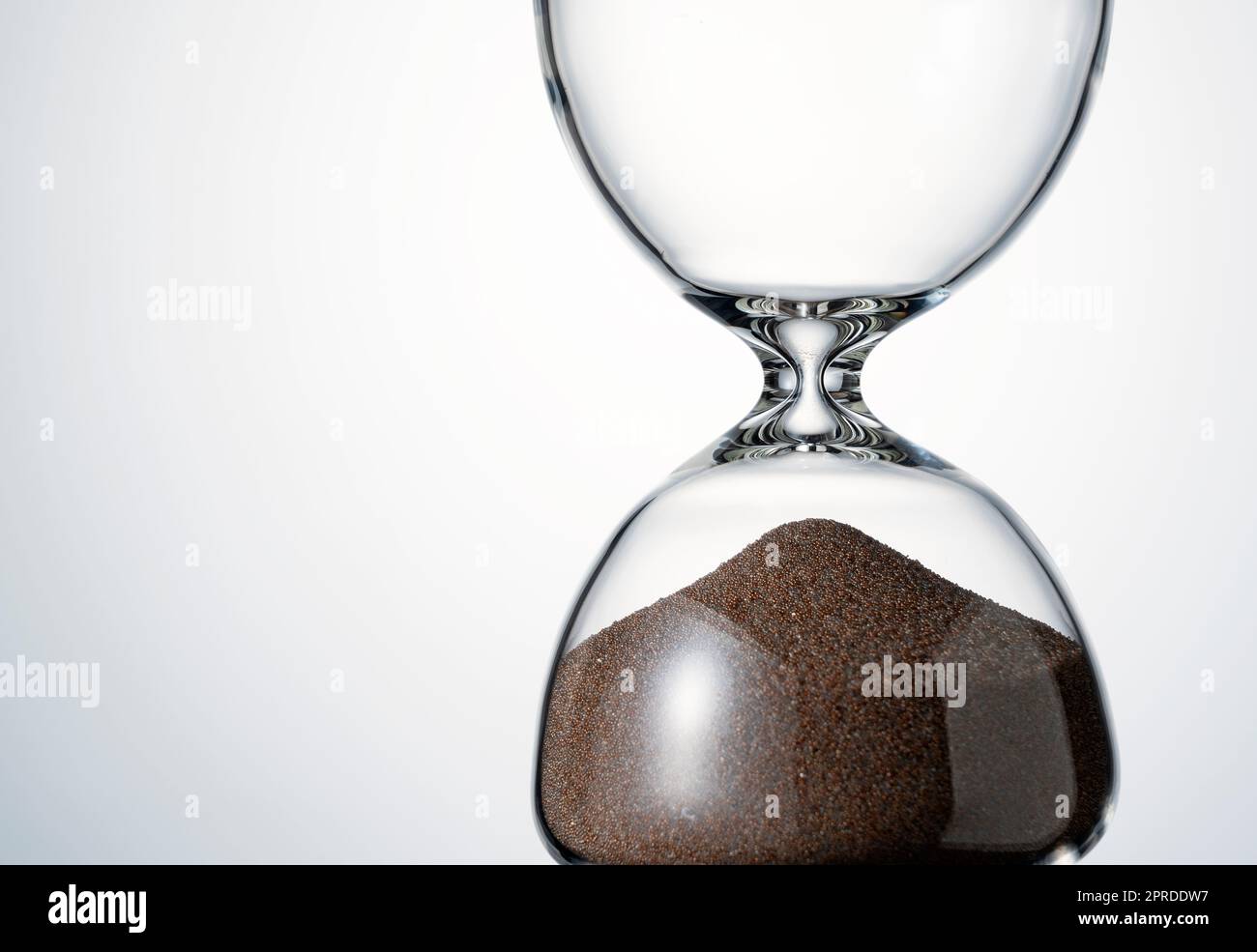 An hourglass placed on a white background. Stock Photo